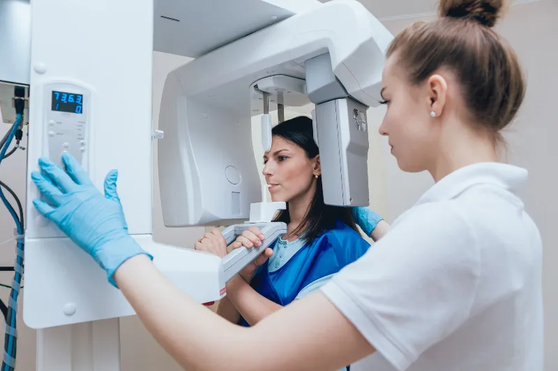 Patient standing in x-ray machine for her teeth