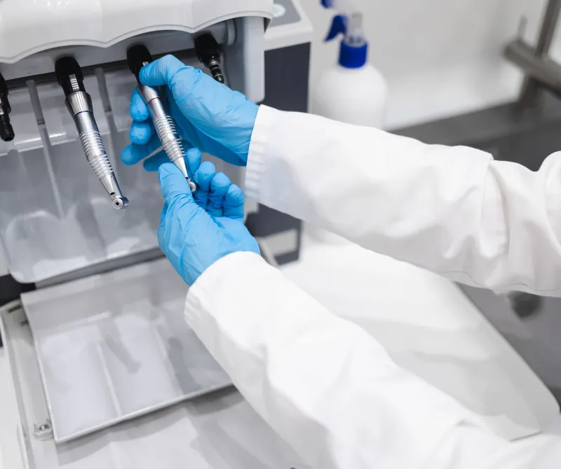 dentist using dental handpiece cleaning and lubricating machine