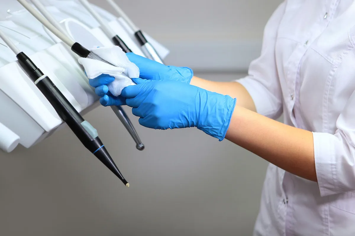 Dentist with gloves cleaning the dental tools