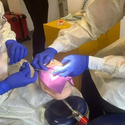 Dental students wearing protective gowns and gloves practise clinical techniques